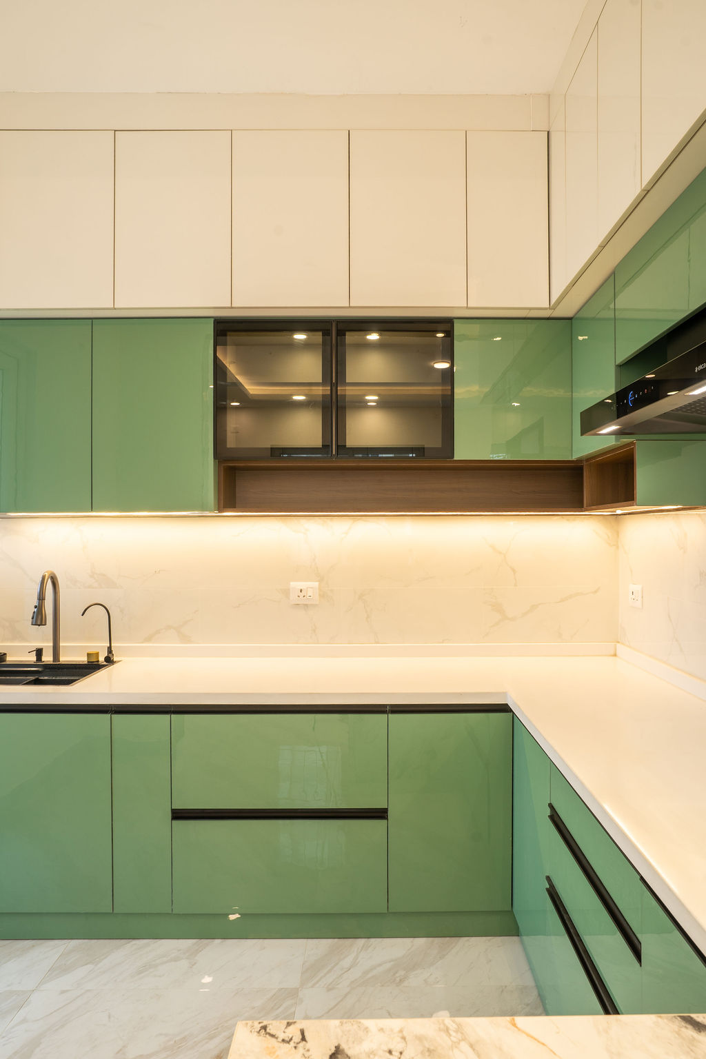 Kitchen with lit glass display cabinets and marble backsplash