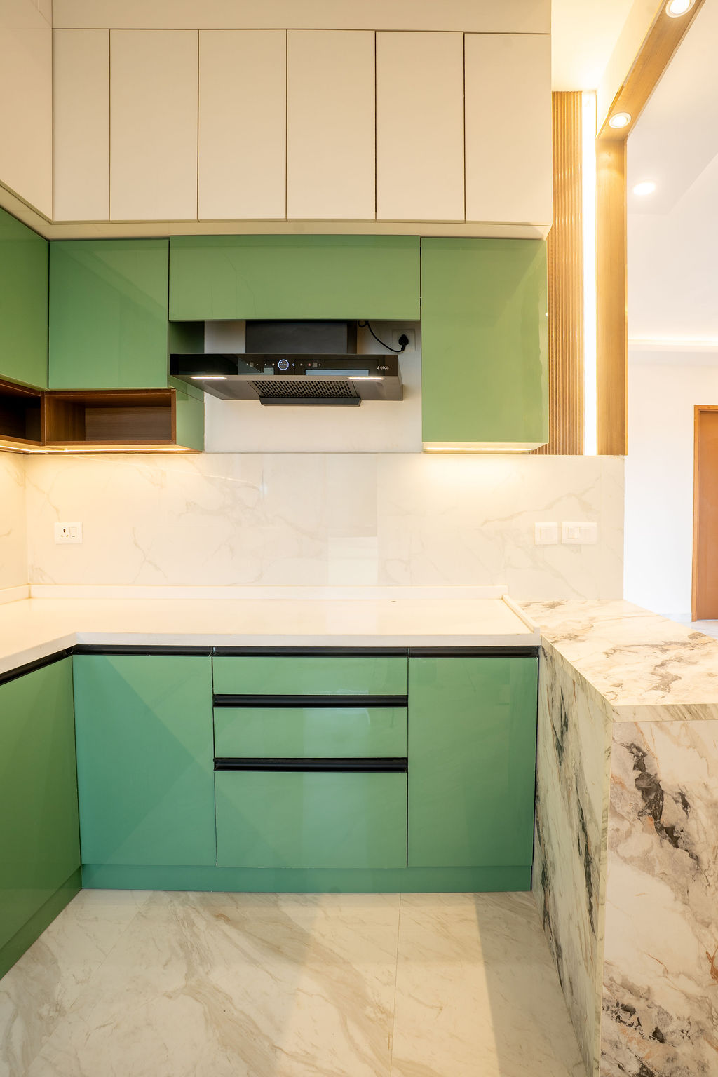 Green kitchen drawers beside a marble ledge