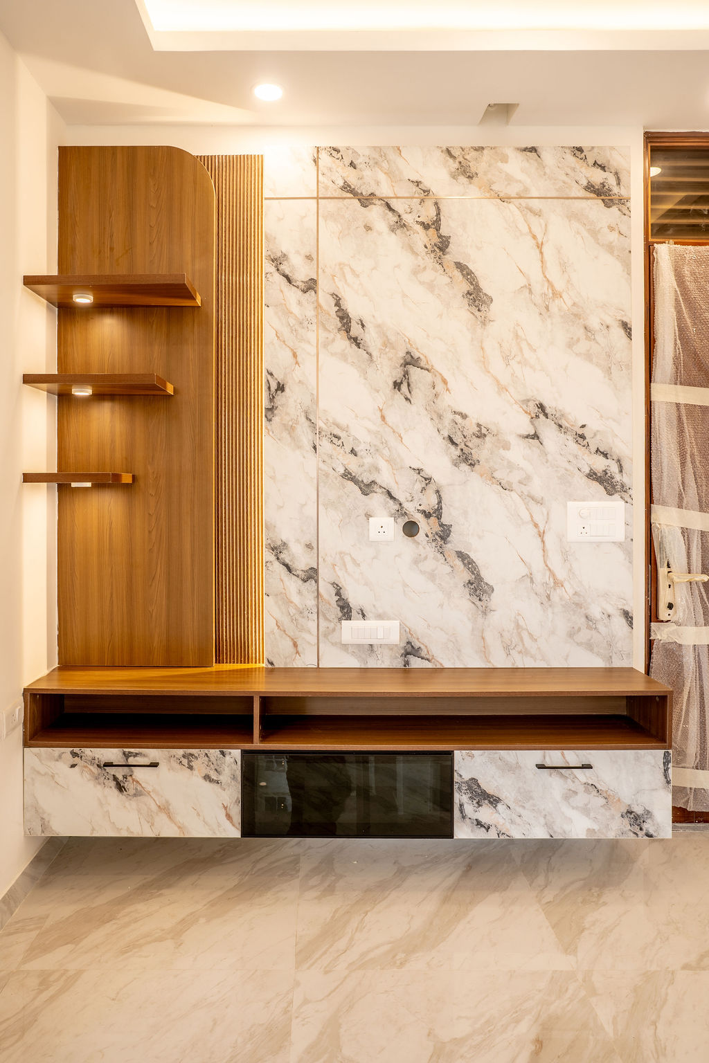 TV unit with marble wall panel, teak shelves and fluted wood detail