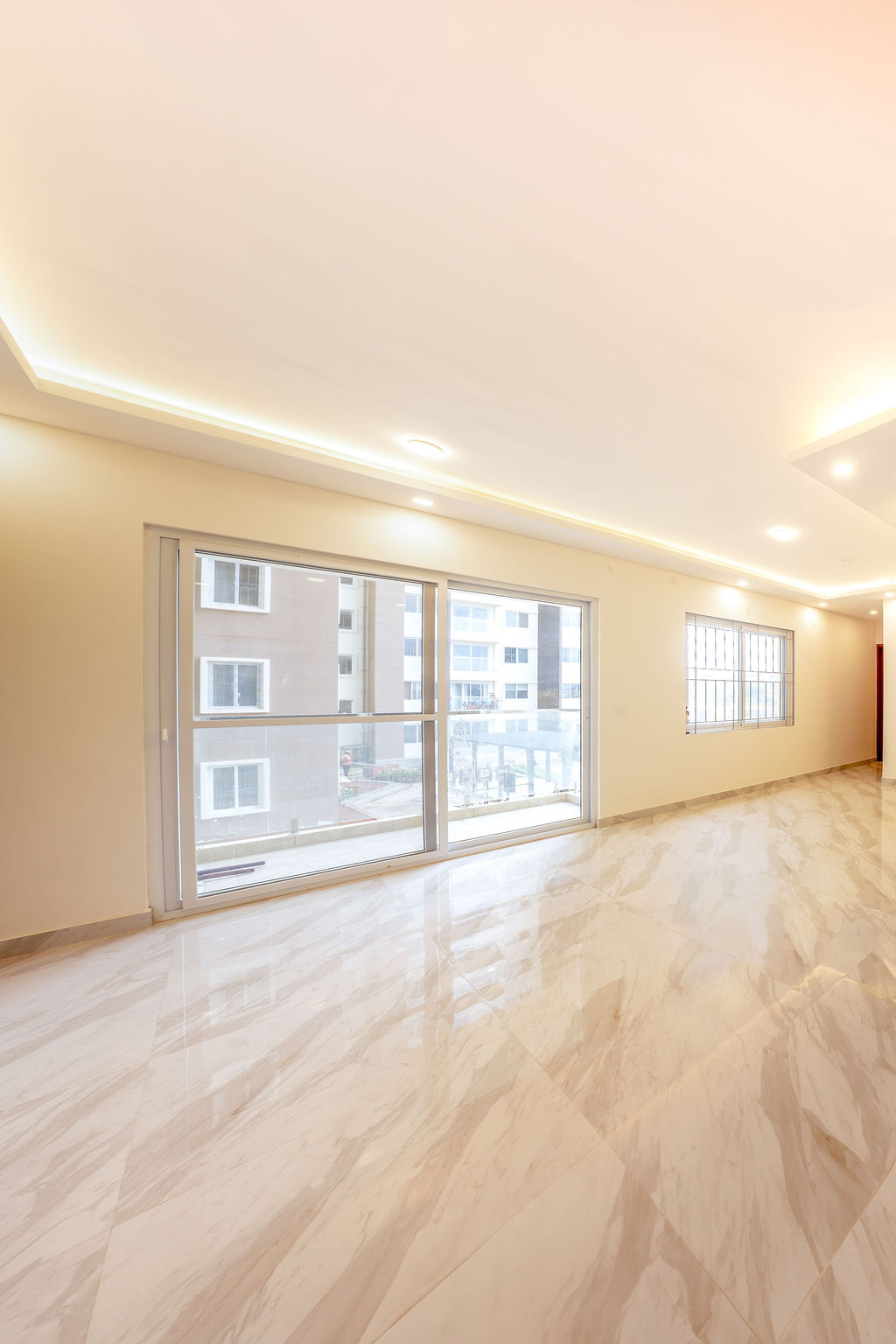 Bright living room with cove lighting and marble flooring