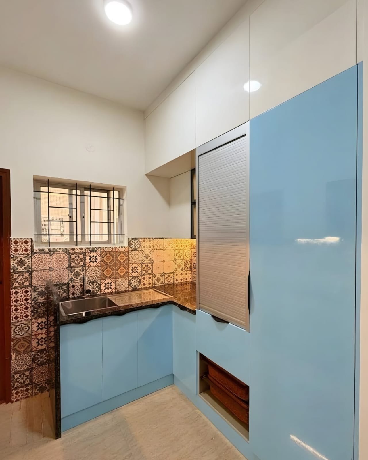 Blue and white L-shaped kitchen with tall storage unit