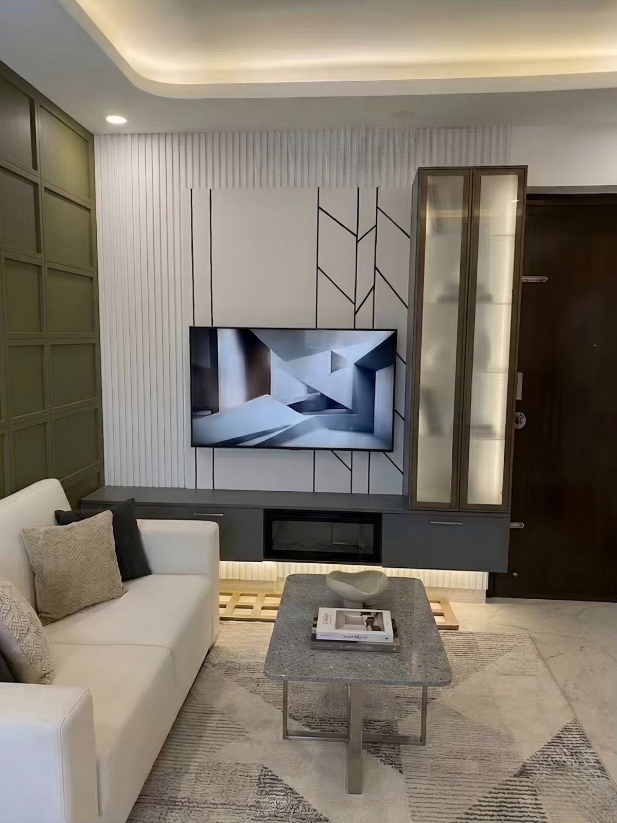 Living room with fluted white TV panel, olive accent wall and glass display cabinet