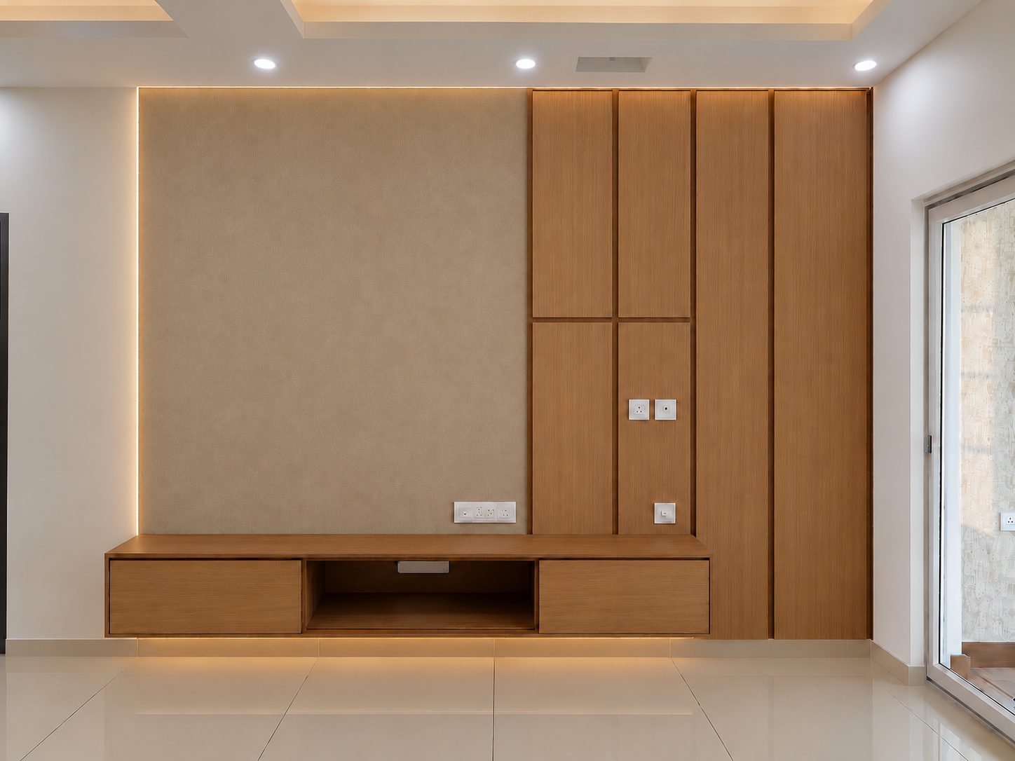 Floating oak TV console with cove lighting and textured wall panel, 2 BHK interior Sarjapur Road