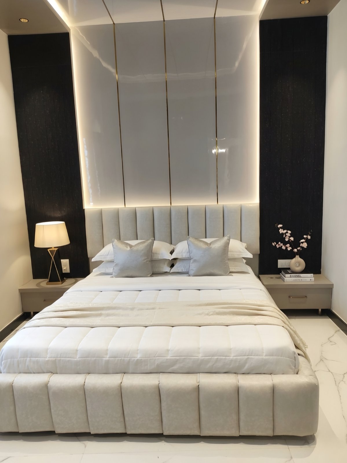 Bedroom with backlit onyx-and-gold headboard panel, channel-tufted bed and black fluted side panels
