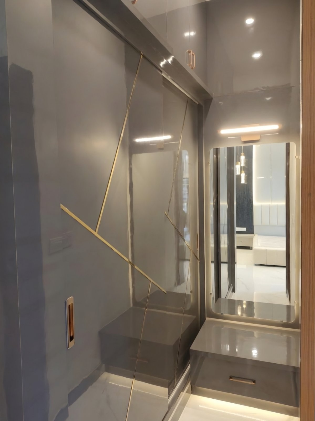 Grey high-gloss wardrobe with gold inlay lines and a mirrored dresser